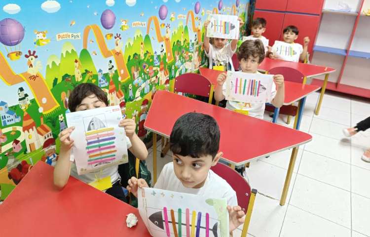 بازی و ریاضی .دانش‌آموزان طبق الگو برای شناخت رنگ‌ها چوب‌بستنی را روی کاربرگ ماهی چسباندند. 1