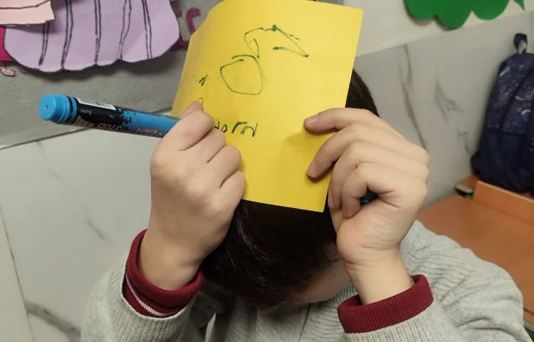 تمرین spelling کلمات جدید توسط دانش آموزان روی کاغذ و بر روی سرشان 2