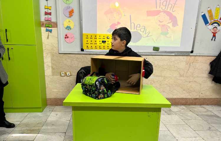 دانش آموزان سبک و سنگین بودن اجسام را با لمس کردن انها داخل باکس میسنجند 1